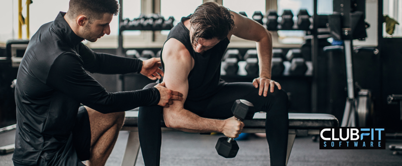 trainer helping out new gym member trainer helping out new gym member