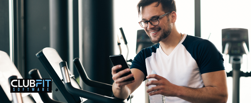 gym member reading email on their phone gym member reading email on their phone