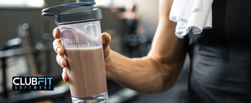 gym member holding protein shake gym member holding protein shake